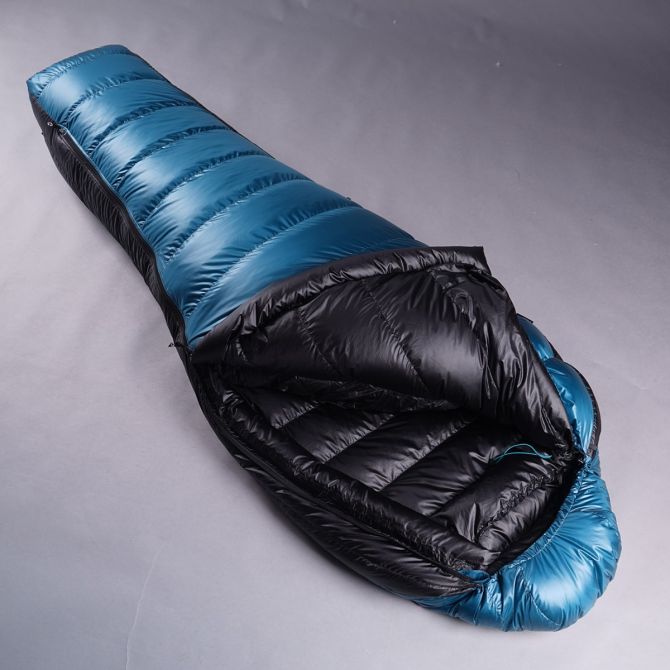 Rozložený pootevřený péřový spacák Cumulus Teneqa 700 ve světlé modré barvě.