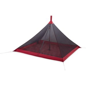Looking up at the red-tipped peak of a gray and red tent against a white sky, with tent poles visible inside.