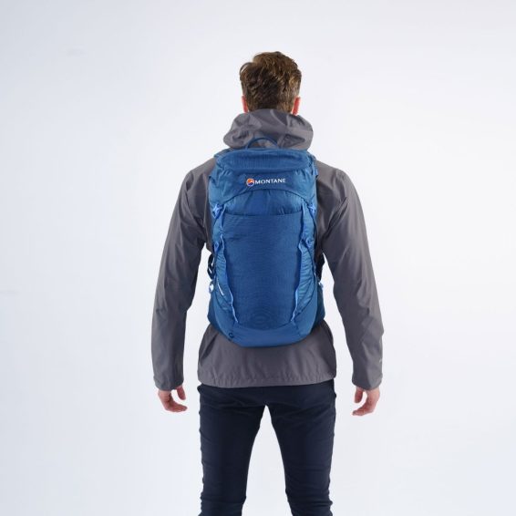 Osoba s batohem Montane Traiblazer 30 na zádech v modré barvě.