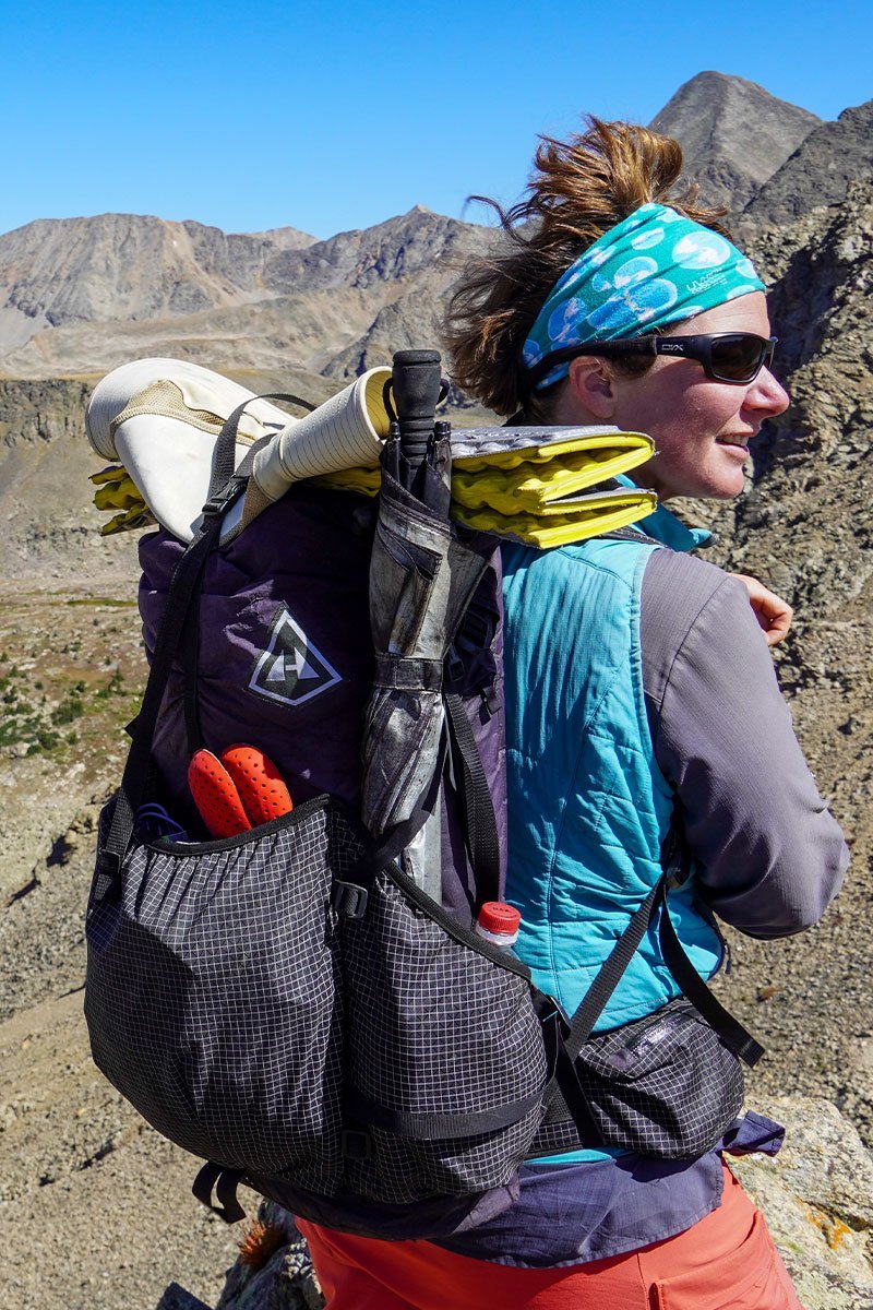 Hyperlite Mountain Gear Packs 3400 Southwest 28479546327085 Osoba s batohem Batoh Hyperlite Mountain Gear 3400 Southwest Black - na zádech, s příslušenstvím sbaleným v síťované kapse a karimatkou na batohu