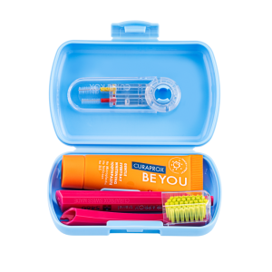 Blue travel dental kit open: toothpaste, small toothbrush, floss picks and accessories inside a light blue case