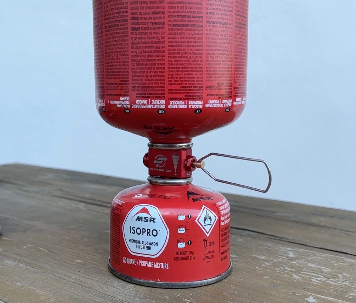 Praktické zařízení pro přenos plynu mezi poloprázdnými isobutanovými kartušemi.