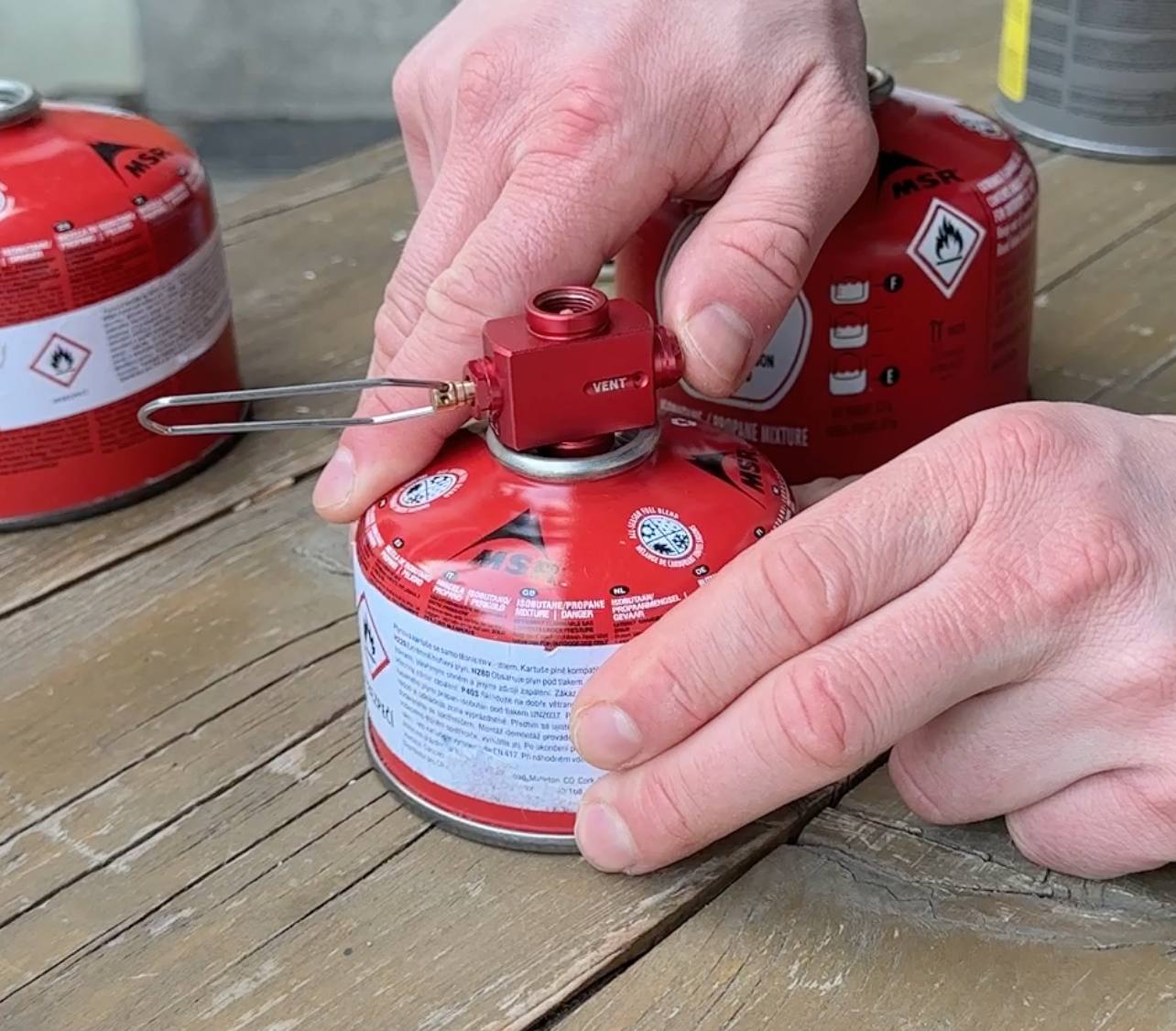 Praktické zařízení pro přenos plynu mezi poloprázdnými isobutanovými kartušemi.