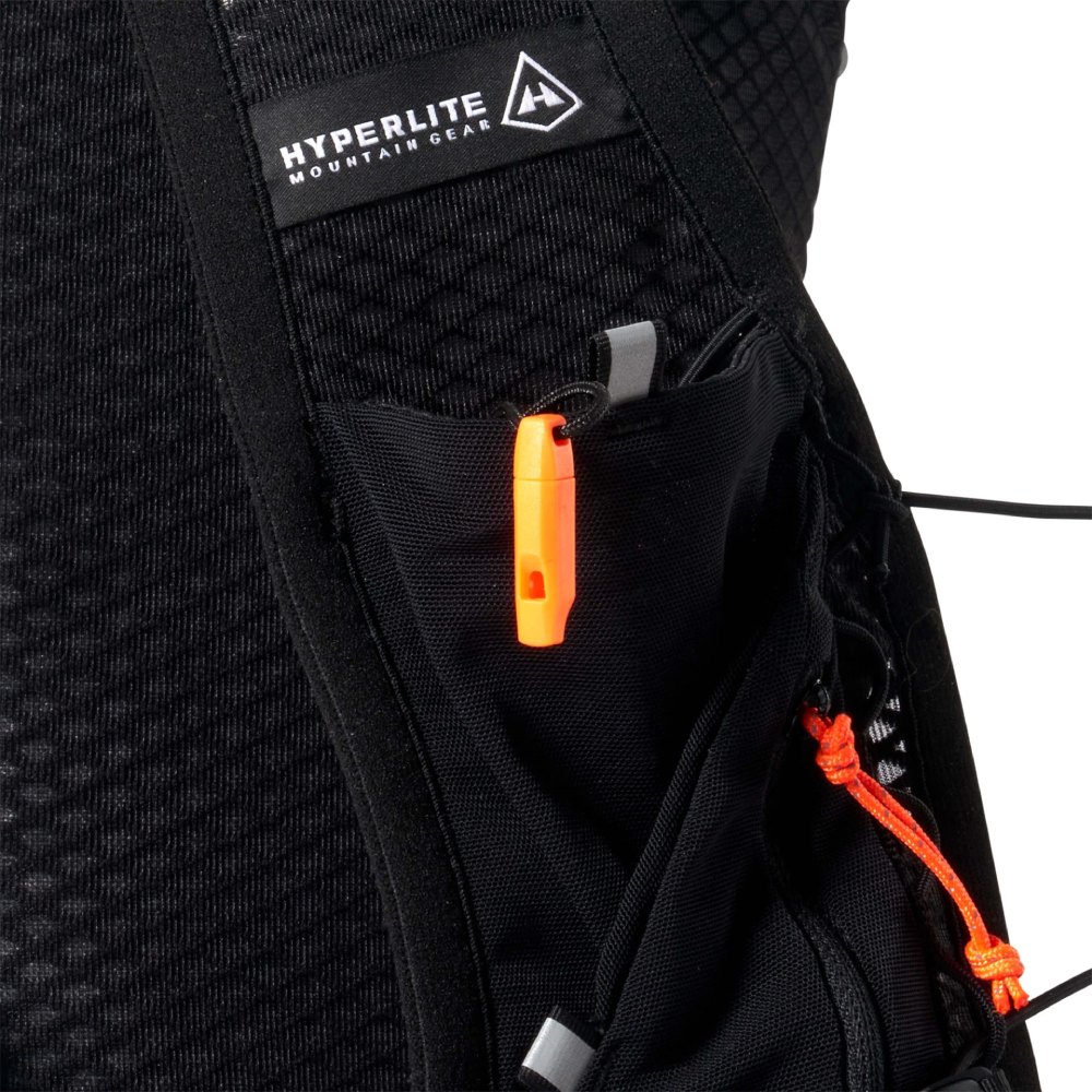 Close-up of a black Hyperlite Mountain Gear backpack showing an orange zipper pull and cord locks in the pocket.