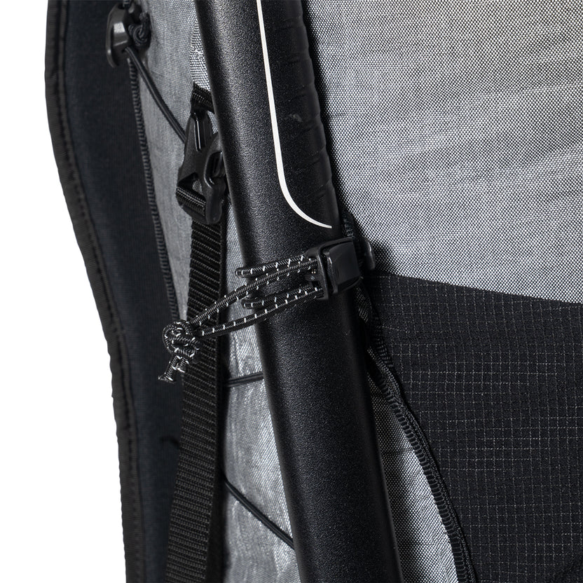 Close-up of a backpack side showing a black zipper with a cord and a plastic cord lock on gray fabric.