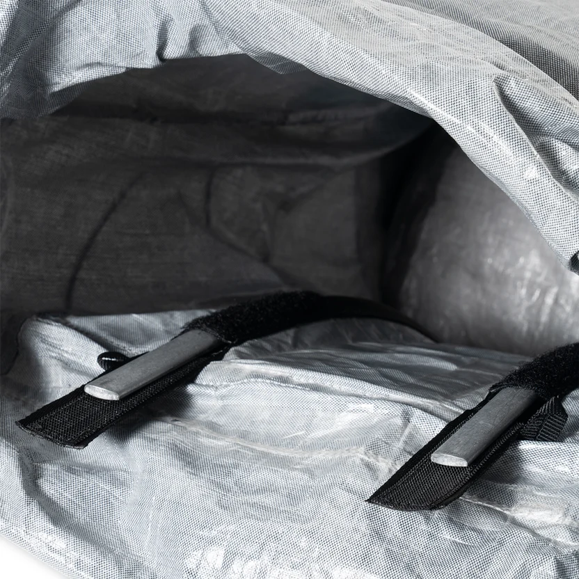 Interior view of a grey backpack's main compartment, featuring two black adjustable straps with buckles.