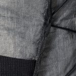 Close-up of gray, woven backpack fabric with a black zipper sewn along a seam.
