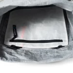 Interior view of a light-gray bag with a white inner zipper pocket labeled 'Hyperlite' and a black zipper pull inside