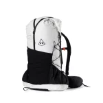 White and black alpine backpack with a large main compartment, front bungee cords, and a padded hip belt; features a side pocket and compact pack design.