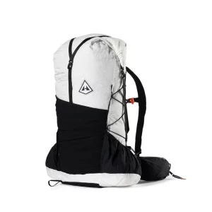 White and black alpine backpack with a large main compartment, front bungee cords, and a padded hip belt; features a side pocket and compact pack design.