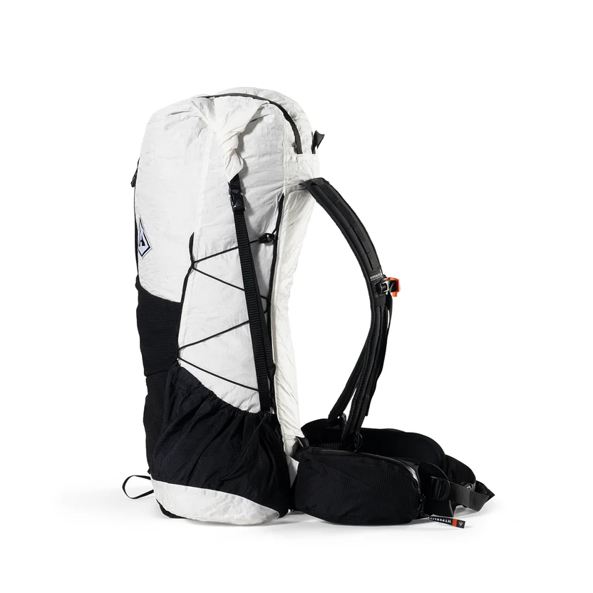 Side view of a white and black hiking backpack with bungee cords, padded shoulder straps, and a waist belt.
