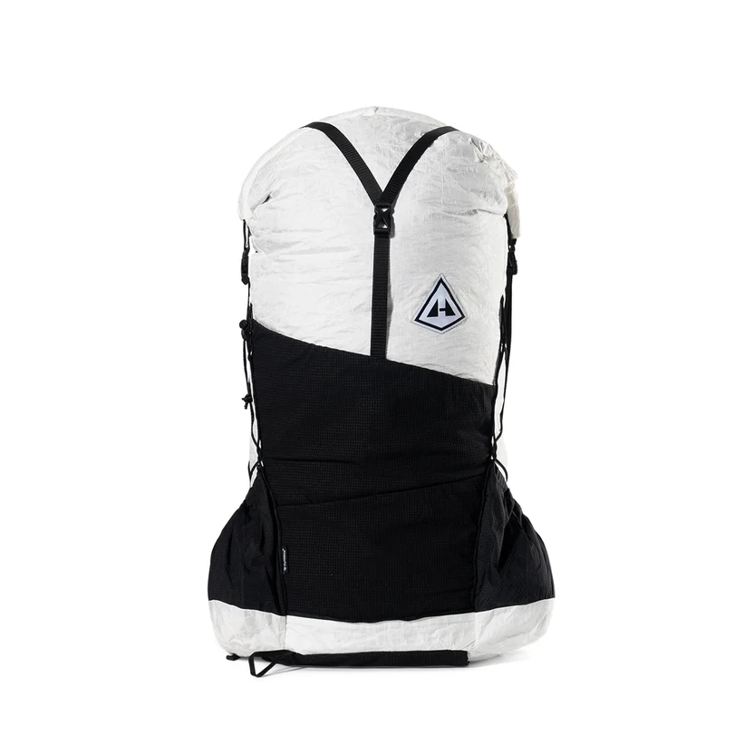 Backpack with white top and black lower section, viewed from behind, with chest strap and side pockets.