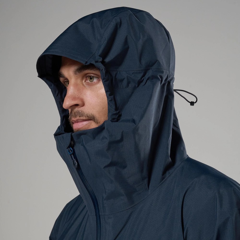 Man in a navy waterproof hooded jacket, side profile with zip front and adjustable drawstring hood.