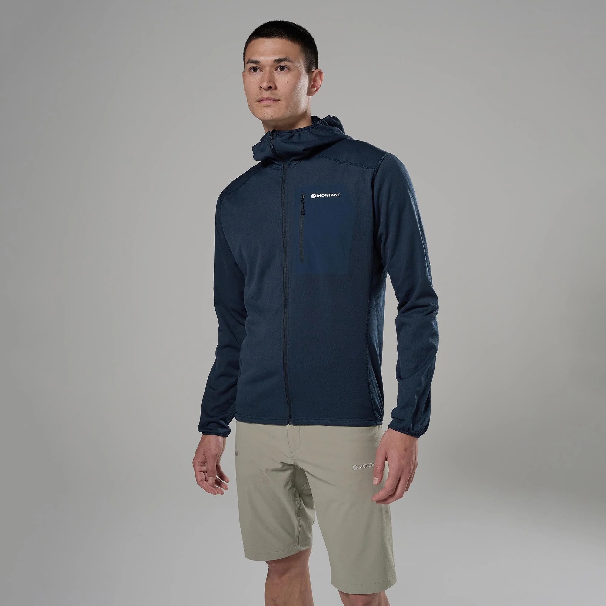 Montane Mens Zepter Hooded Fleece Jacket Eclipse Blue 02 Man modeling outdoor apparel: navy Montane jacket with zippered chest pocket, standing against neutral gray backdrop.