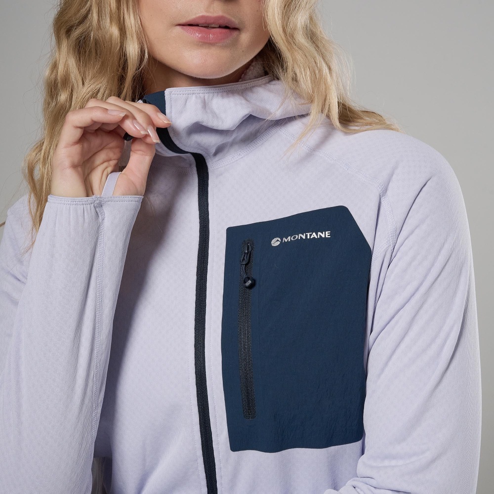 Montane Womens Zepher Hoodie Platinum 05 Woman wearing a lavender Montane jacket with a dark navy zippered chest pocket, posed adjusting the collar toward the zipper edge.
